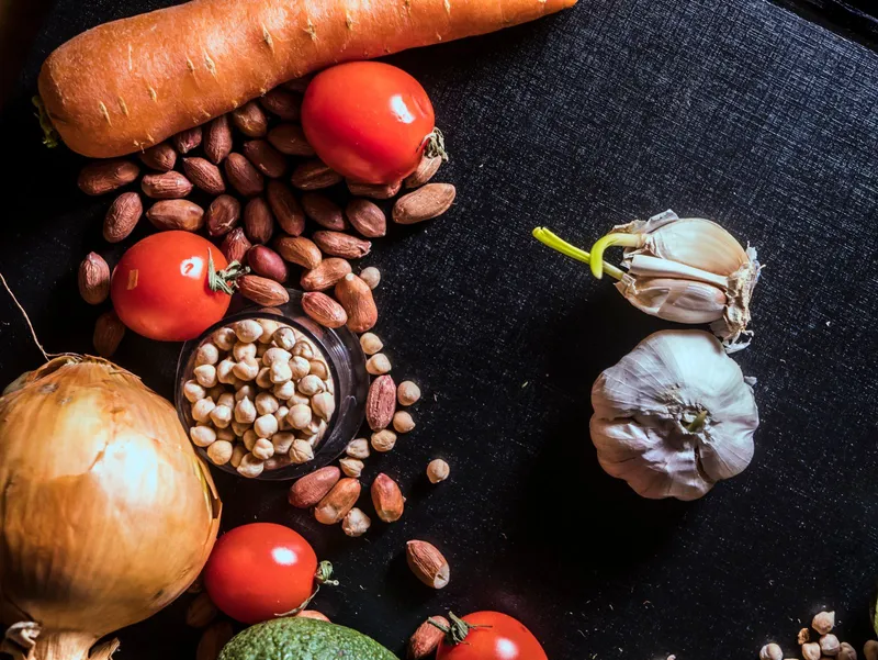 Verduras, legumbres y frutos secos sobre fondo oscuro para una alimentación saludable