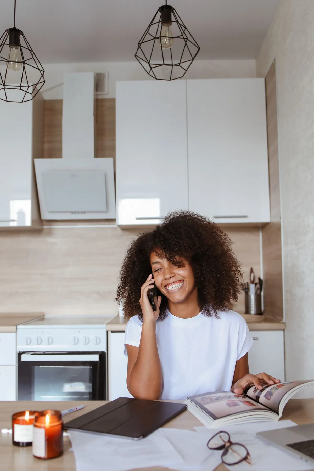 Mujer con auriculares consulta una aplicación de ayuno en su teléfono mientras toma café en la cocina