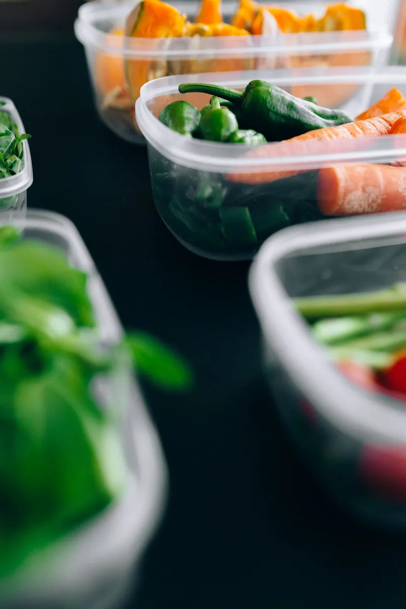 Recipientes de plástico con verduras frescas cortadas listos para el meal prep semanal