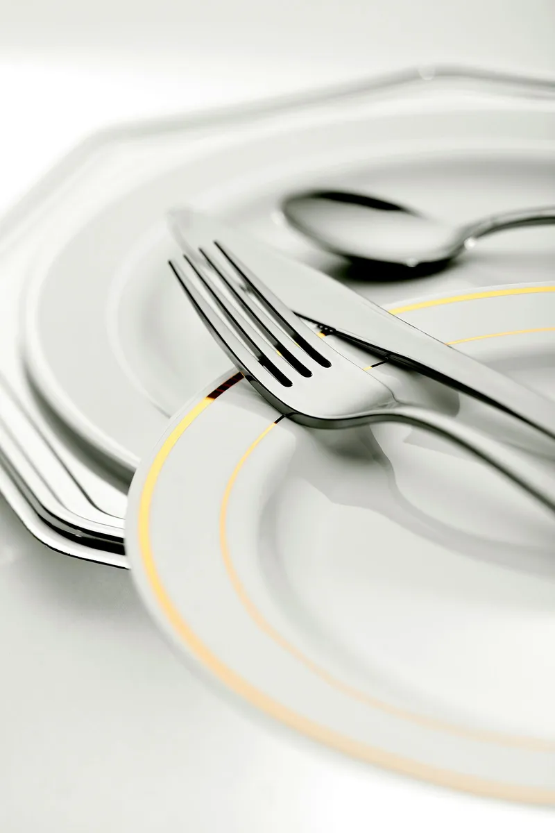 Plato blanco vacío con tenedor, cuchillo y cuchara preparados antes de comer