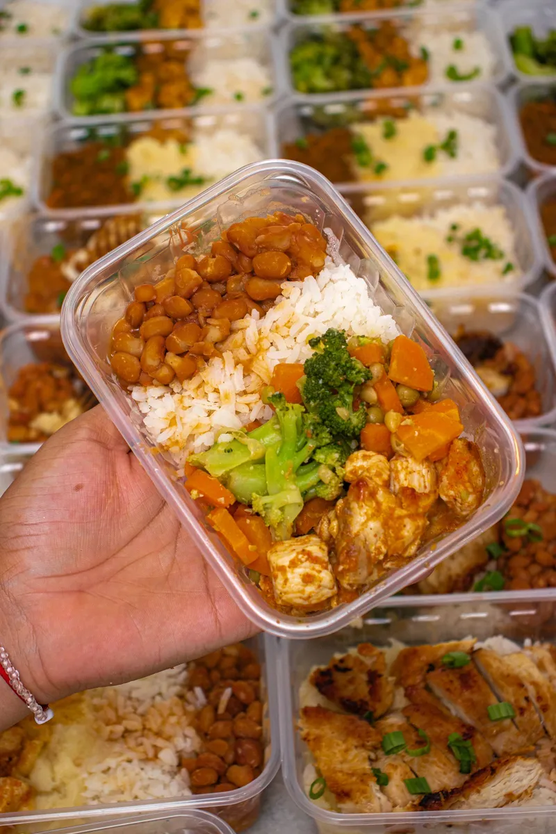 Tupper de preparación de comidas con arroz, legumbres, pollo y verduras para planificar la semana